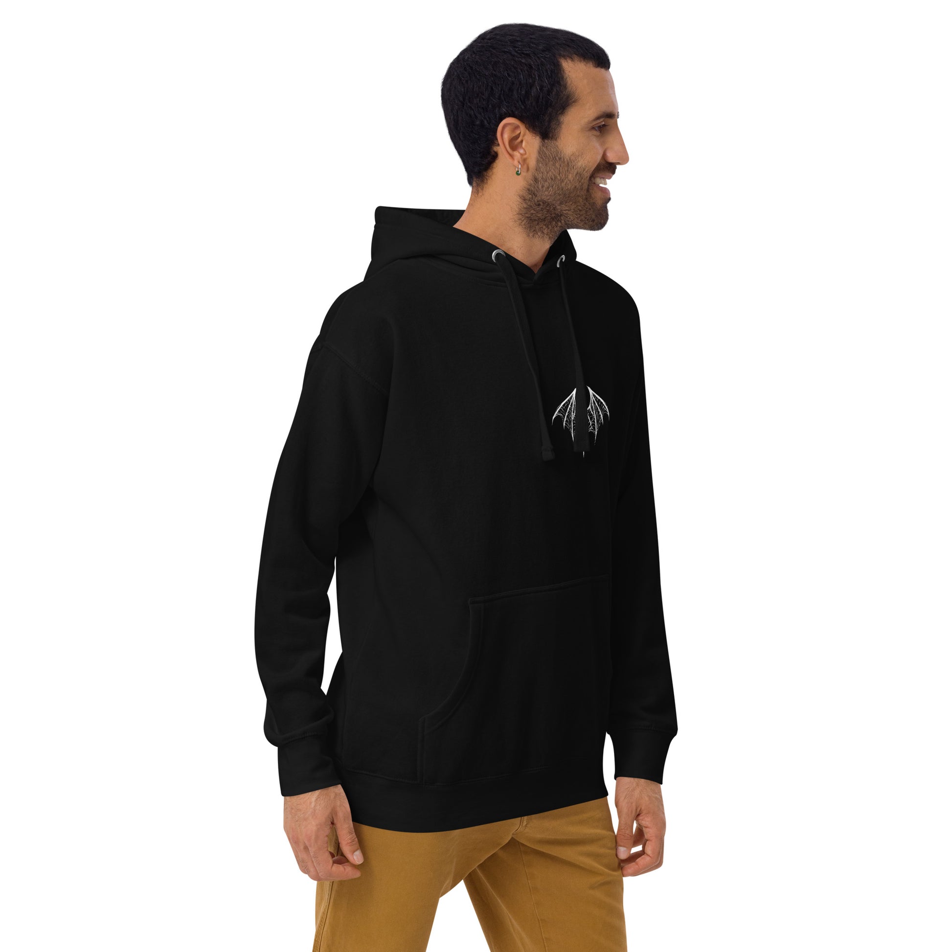  young white man wearing a black hoodie with a white design of a spider-bat hybrid on the left chest. Perfect for those who love dark and unique aesthetics. Spiderbat Unisex Hoodie - DarkSongWear